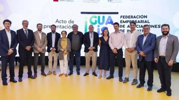 Grupos de personasen semicírculo delante de una pantalla gigante posando para la foto